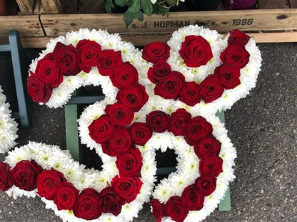 Van Arthur’s red rose Hindu Om Aum floral tribute with a white chrysanthemum border