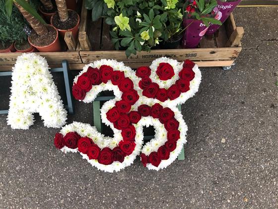 Actual Van Arthur Hindu Om Aum tribute made with red roses and white chrysanthemum edging