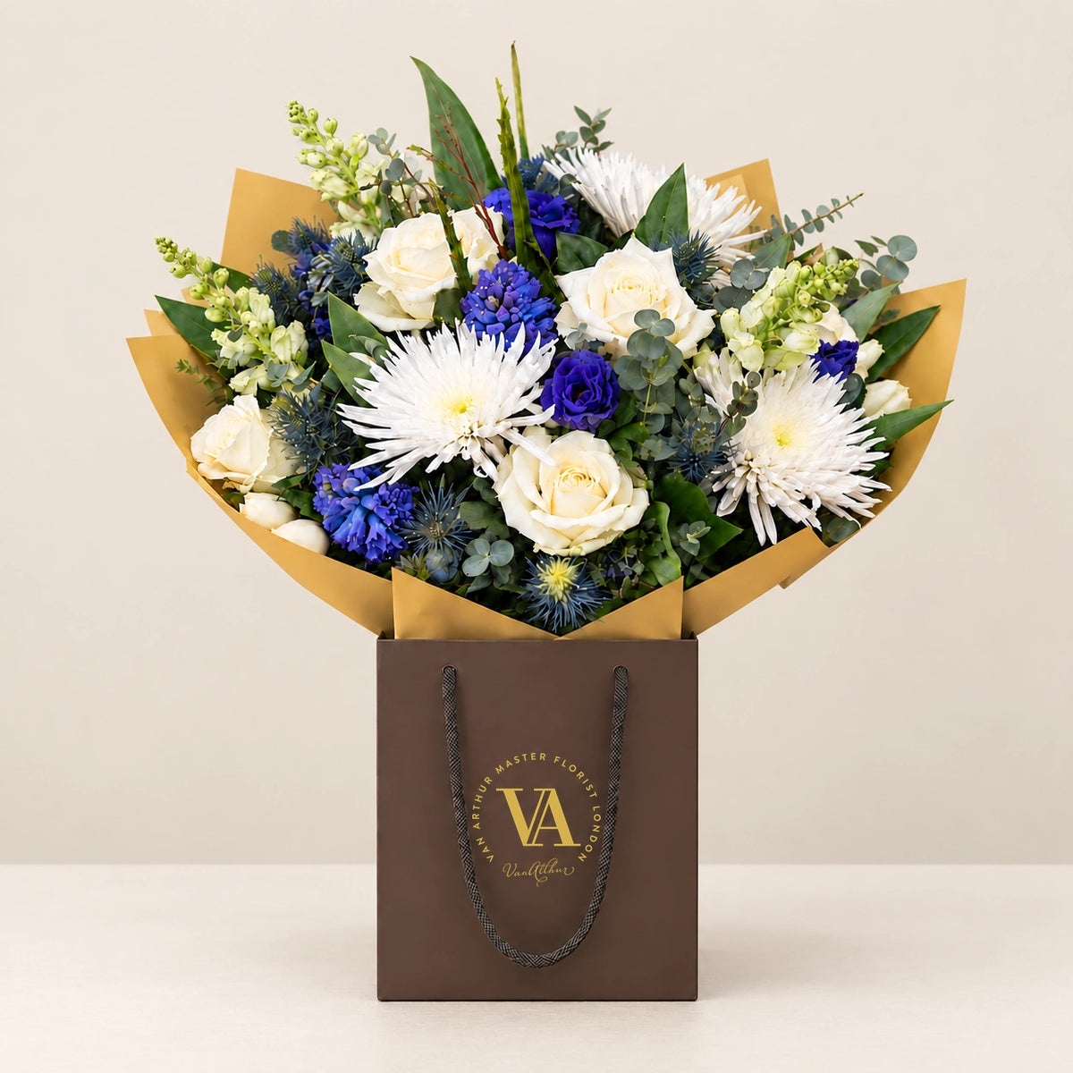 Marina by Van Arthur Master Florist — the bouquet in signature packaging against a quiet backdrop.